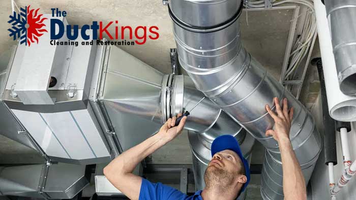 A professional cleaning the air ducts in a residential house.
